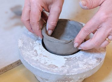 Dettaglio: un utente modella un vaso in ceramica